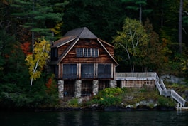 brown wooden house near body of water during daytime