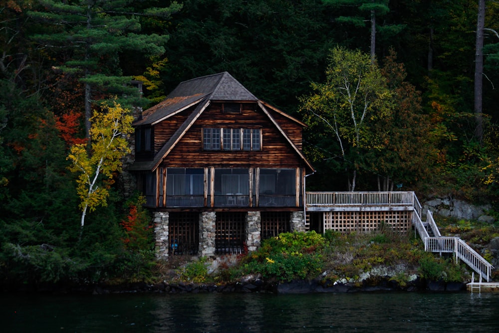 brown wooden house near body of water during daytime