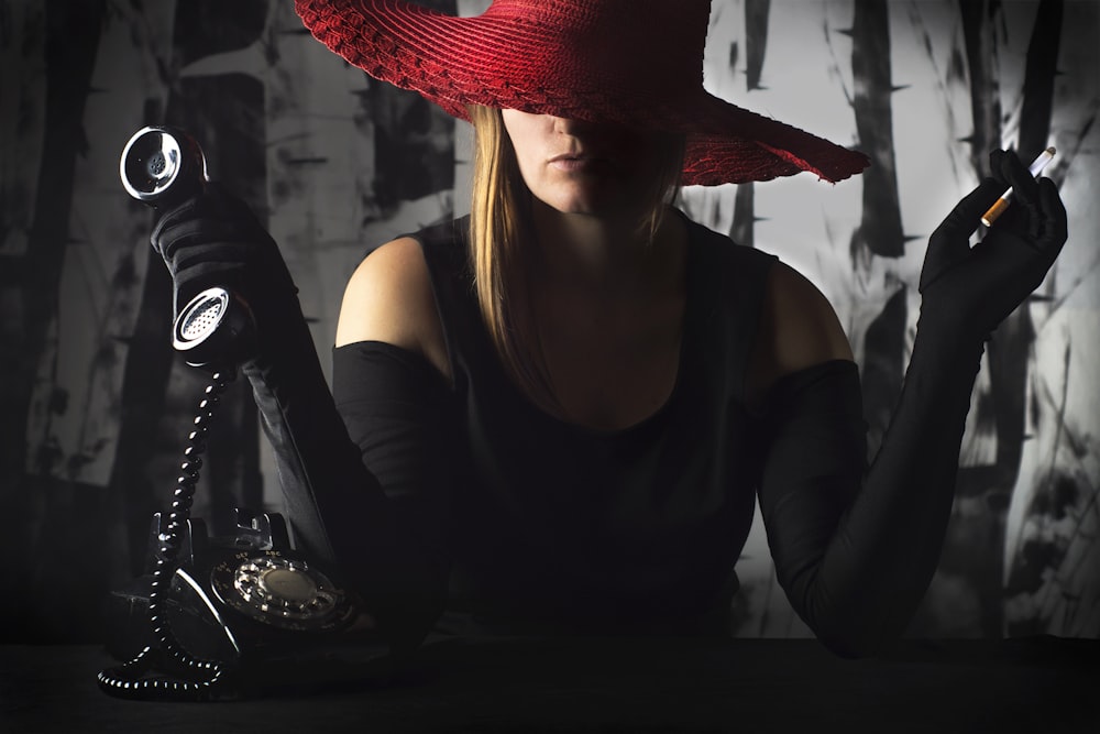 woman in black tank top wearing red fedora hat