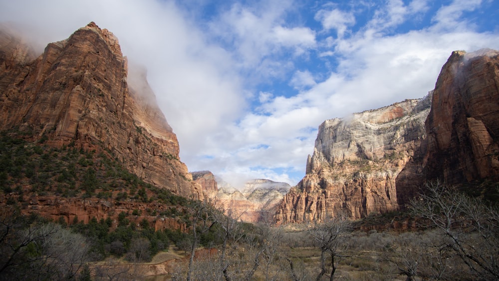 brown rocky mountain under white clouds during daytime