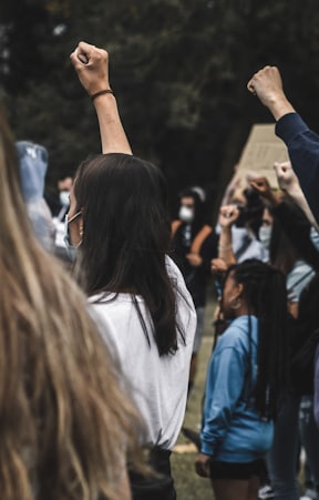 woman in white shirt raising her left hand