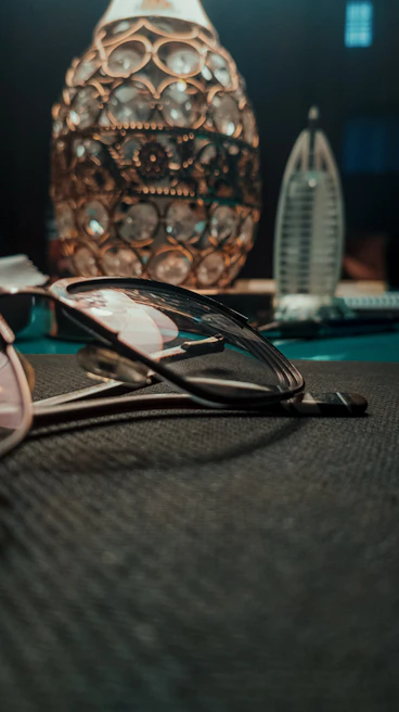 Elegant luxury glasses resting on a sleek black surface with golden light accents