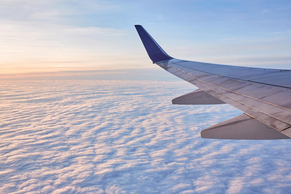 An aircraft wing and winglet above a flat layer of cloud