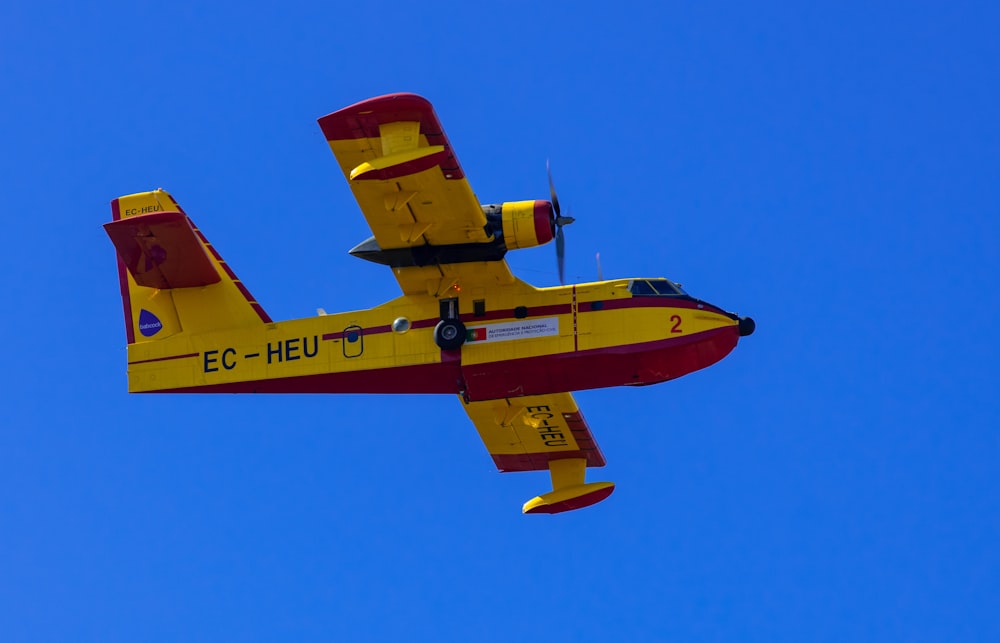red and yellow plane flying in the sky