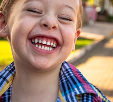 boy in blue white and red plaid button up shirt smiling