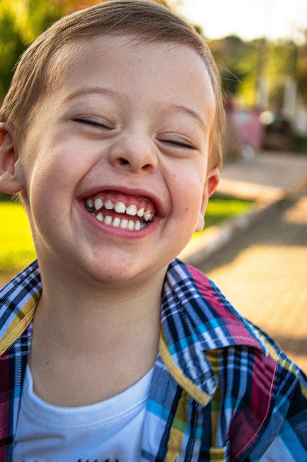 menino em azul branco e vermelho xadrez botão até camisa sorrindo