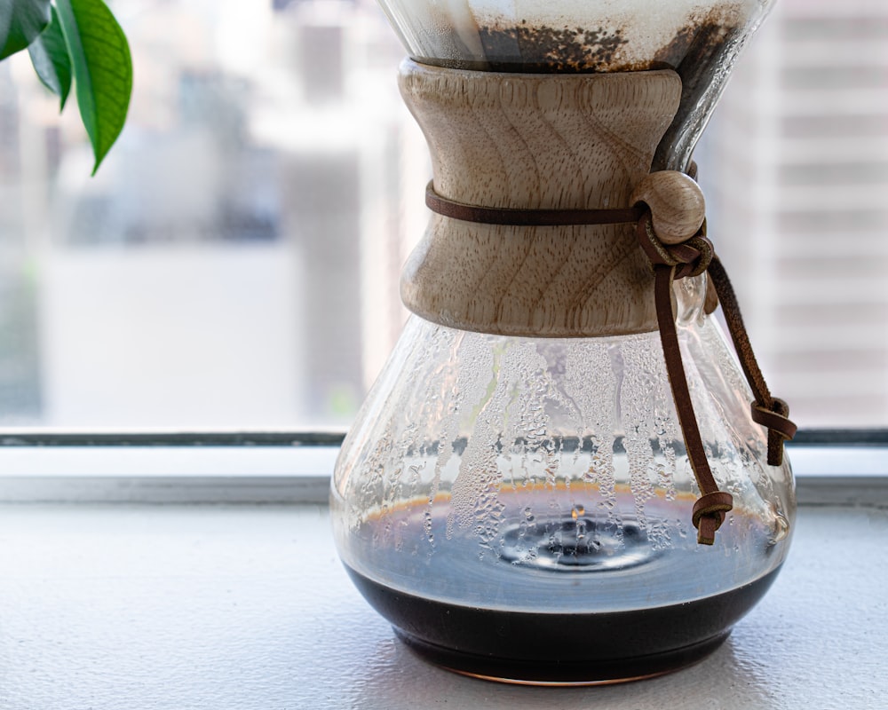 clear glass container with brown wooden stand