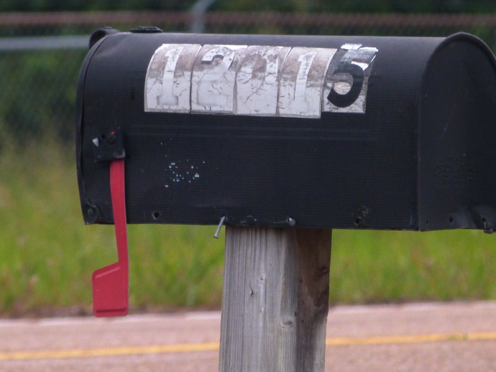 black mail box on red steel post