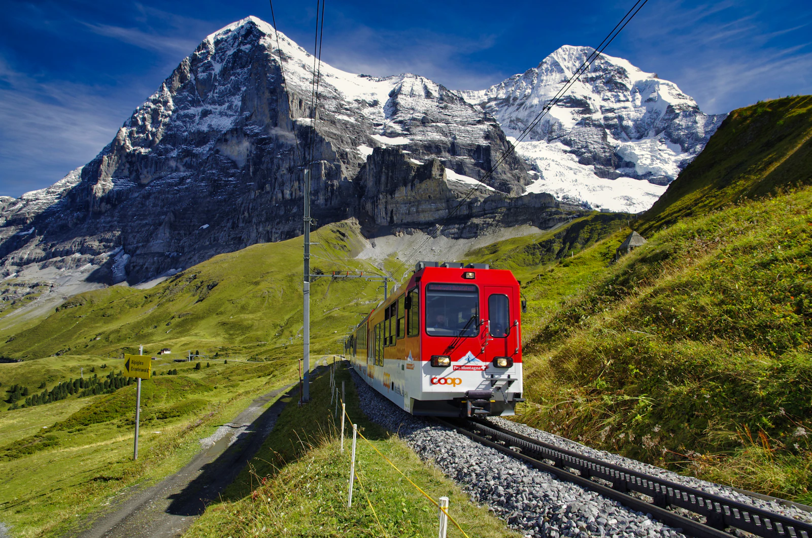 Train rouge et blanc sur une voie de montagne devant un sommet enneigé — photo d'illustration, non prise à Vallorcine