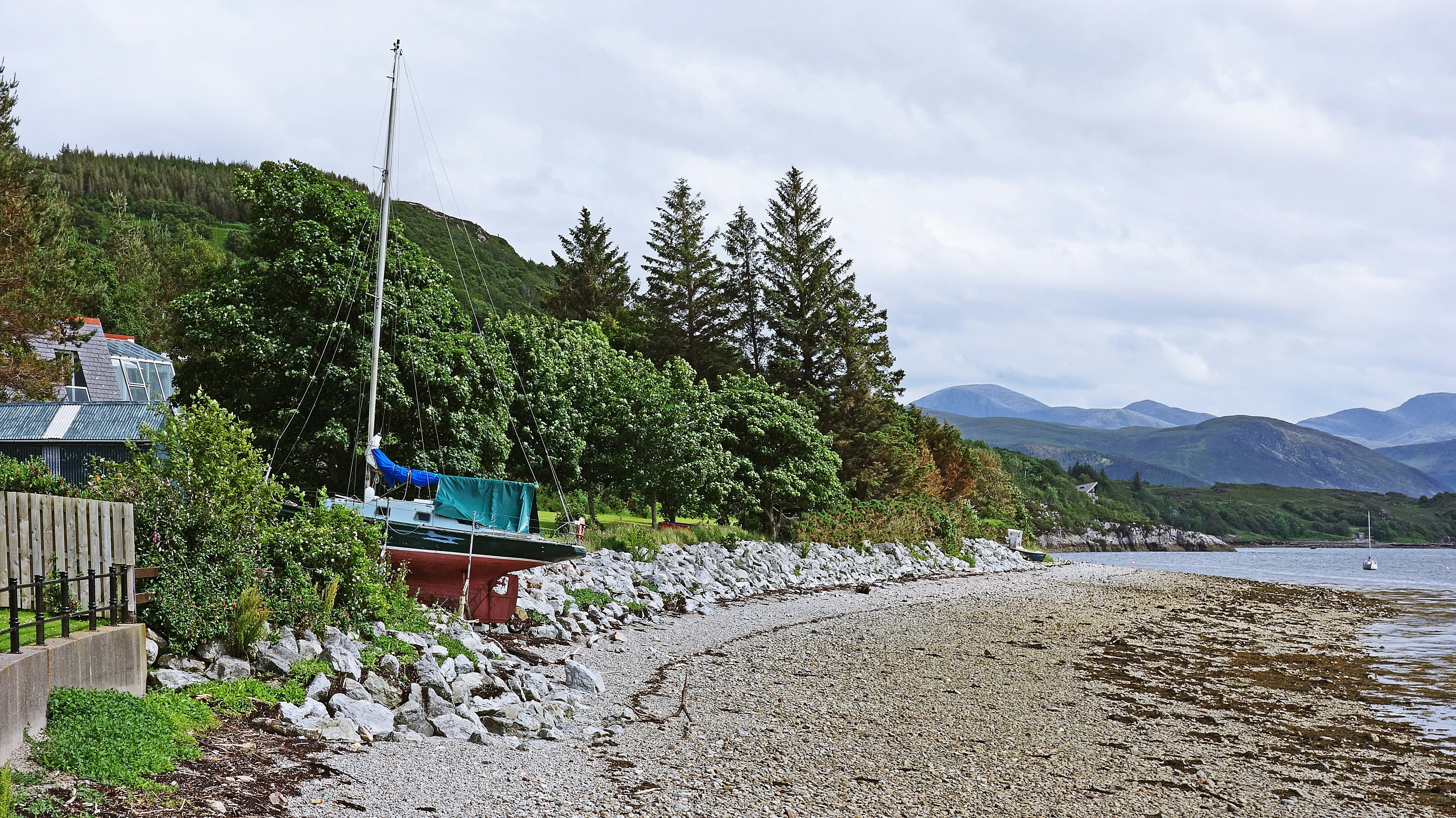 green and red boat on shore during daytime gravel teams background