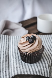 chocolate cupcake with chocolate on white textile