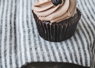 chocolate cupcake with chocolate on white textile