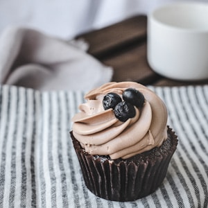 chocolate cupcake with chocolate on white textile
