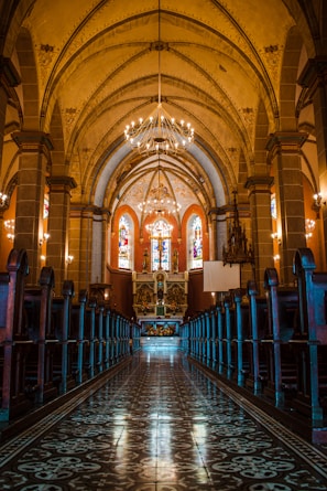 A choir singing hymns in a historic church filled with stained glass windows.