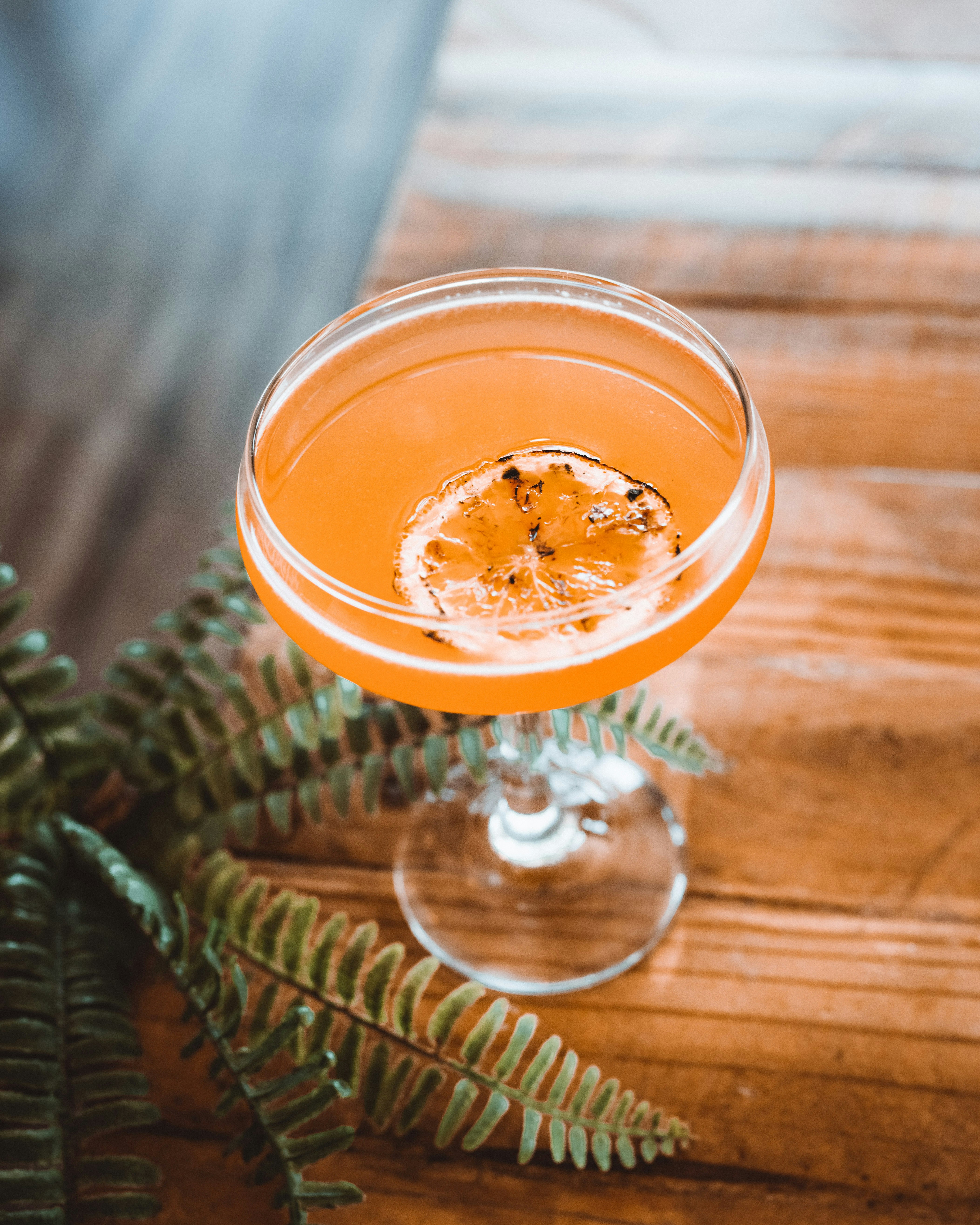 オレンジ色の液体が入った透明なガラスのコップ