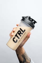 a person holding a coffee cup with the word ctrl on it
