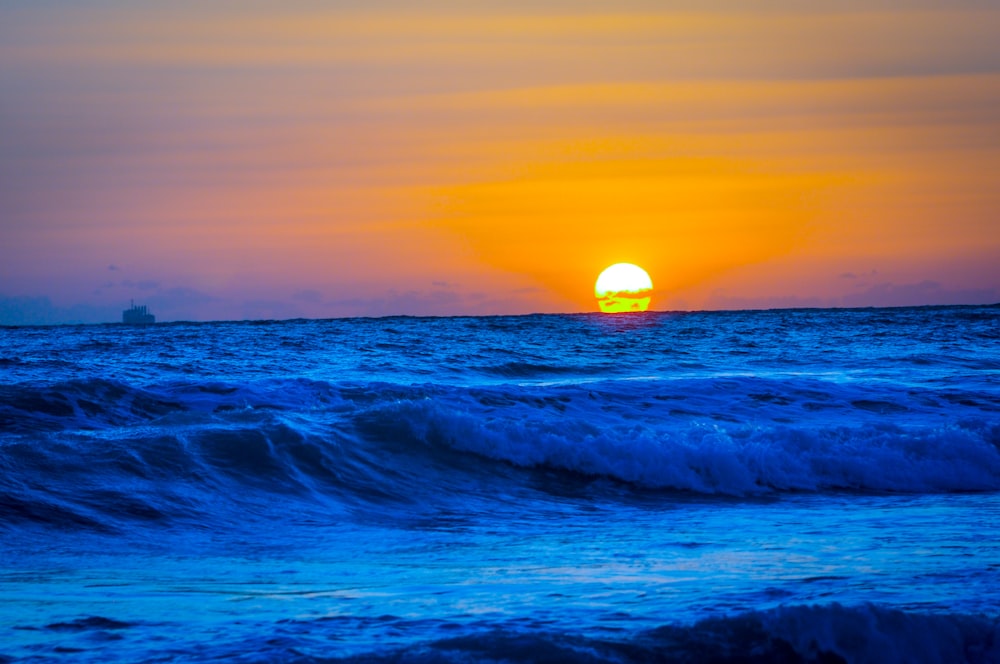 Onde dell'oceano che si infrangono sulla riva durante il tramonto