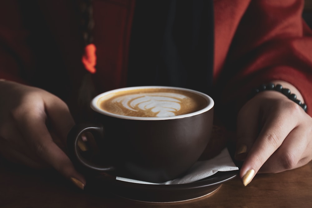 person holding black ceramic mug with coffee