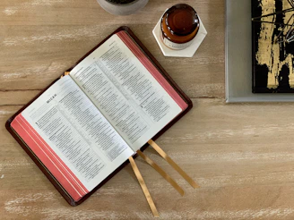 white and red book page on brown wooden table