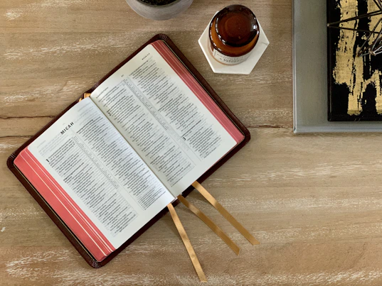 white and red book page on brown wooden table