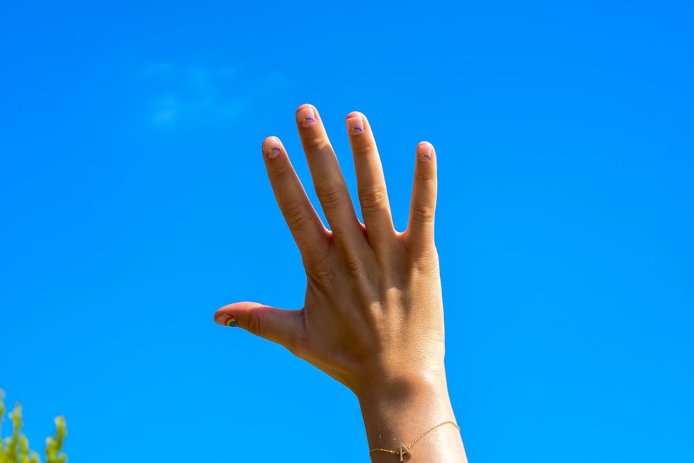 persona con pulsera de oro y pulsera de oro