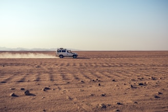 white suv on brown sand during daytime