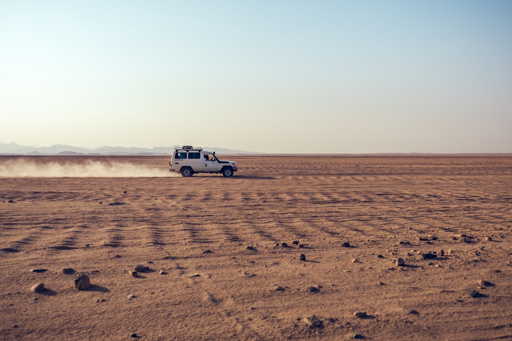 white suv on brown sand during daytime