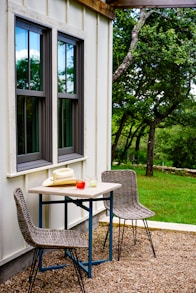 black metal table and chairs near green tree during daytime