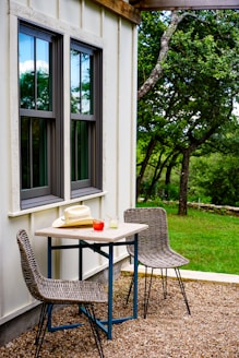 black metal table and chairs near green tree during daytime