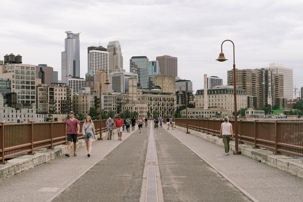 people walking on sidewalk near city buildings during daytime