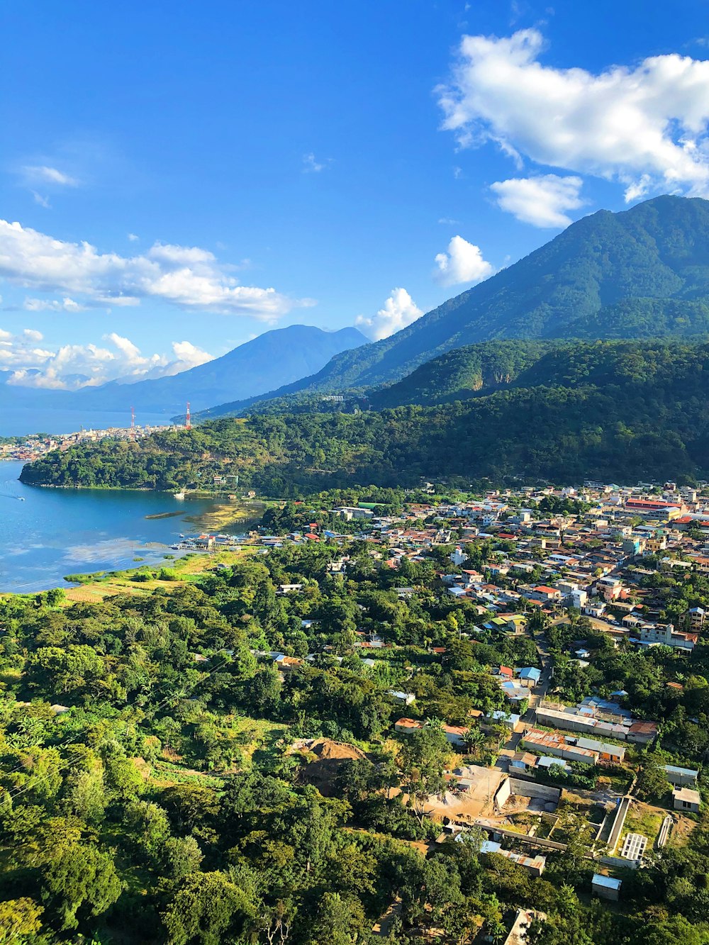 green mountain beside body of water during daytime