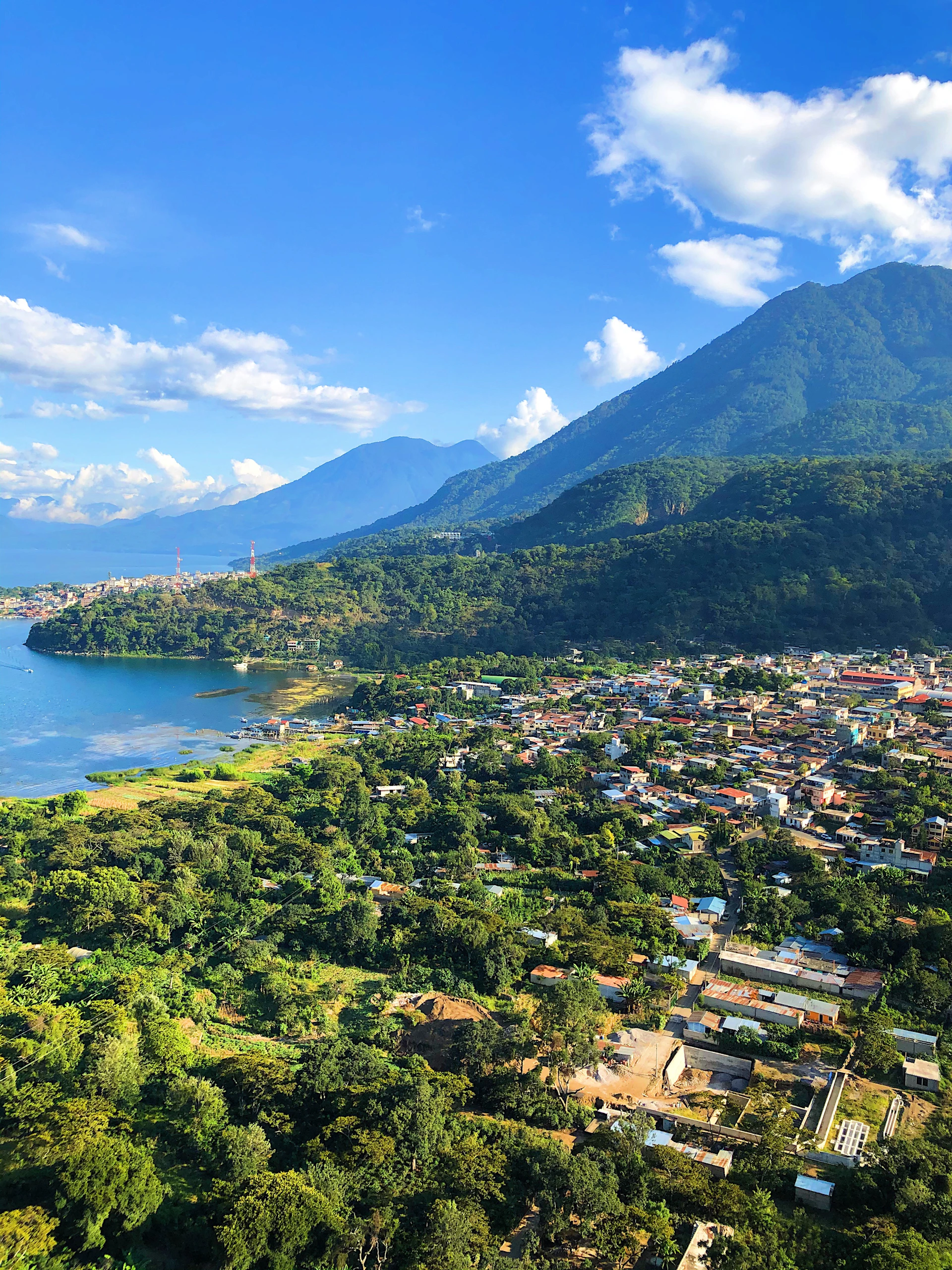 green mountain beside body of water during daytime