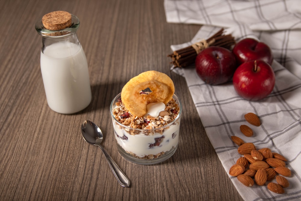 white and brown cake on white ceramic plate beside stainless steel spoon and clear glass jar