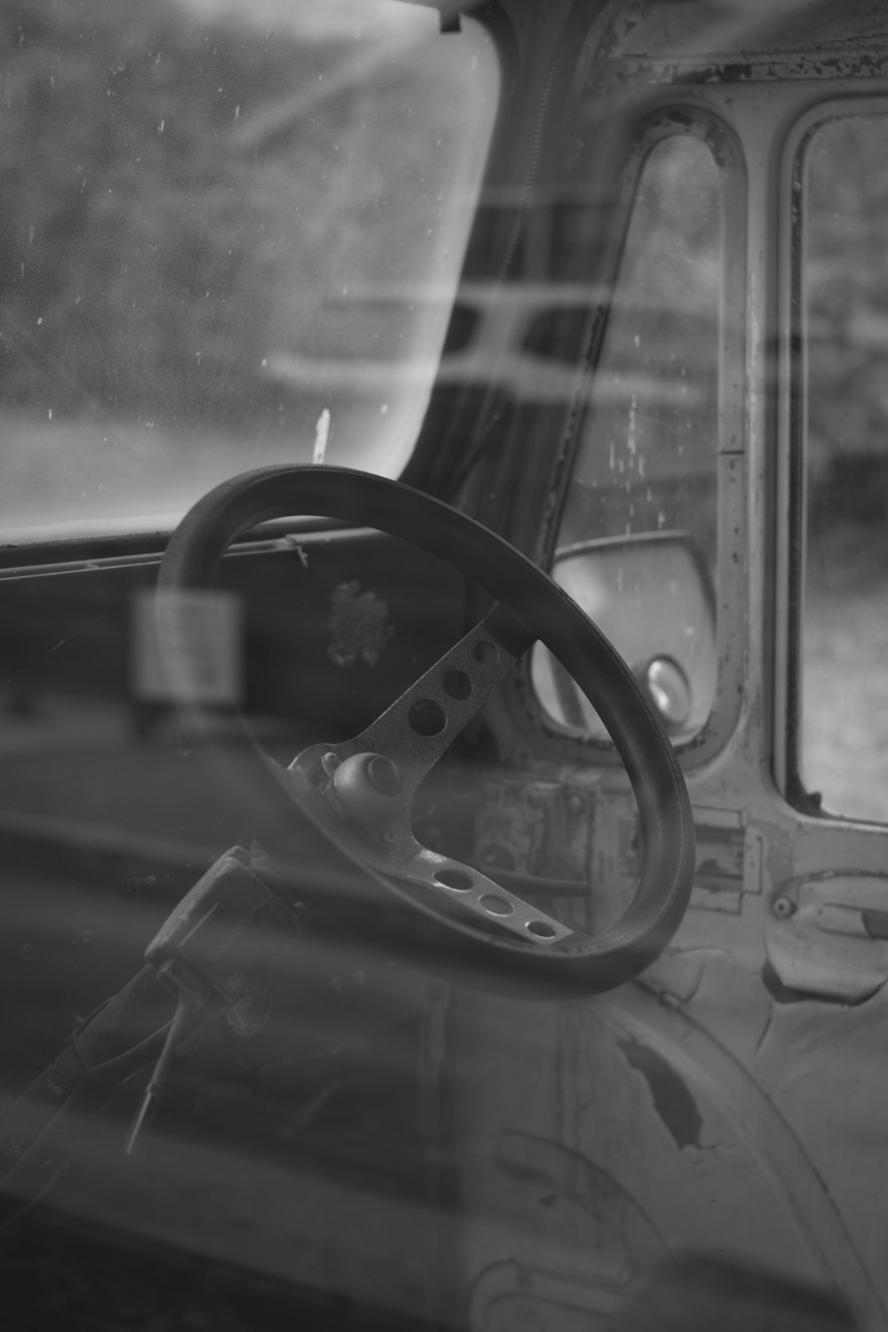 grayscale photo of car steering wheel