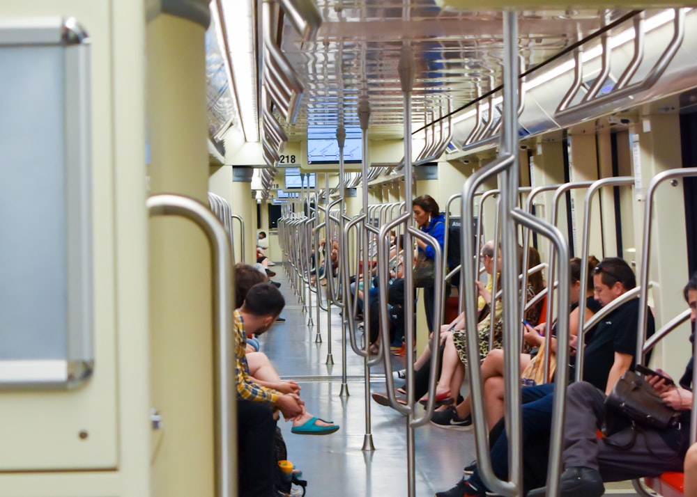 people sitting on blue chairs inside train