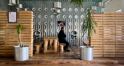 man in black suit sitting on brown wooden bench libya teams background