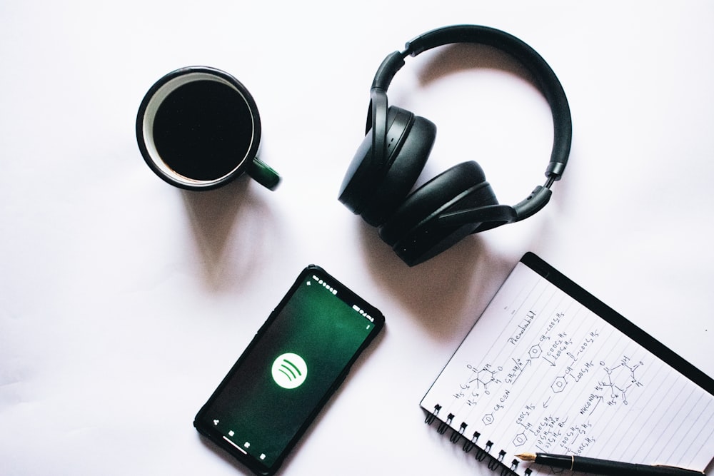 black and silver headphones beside black ipad