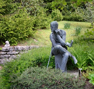 gray concrete statue of man holding stick