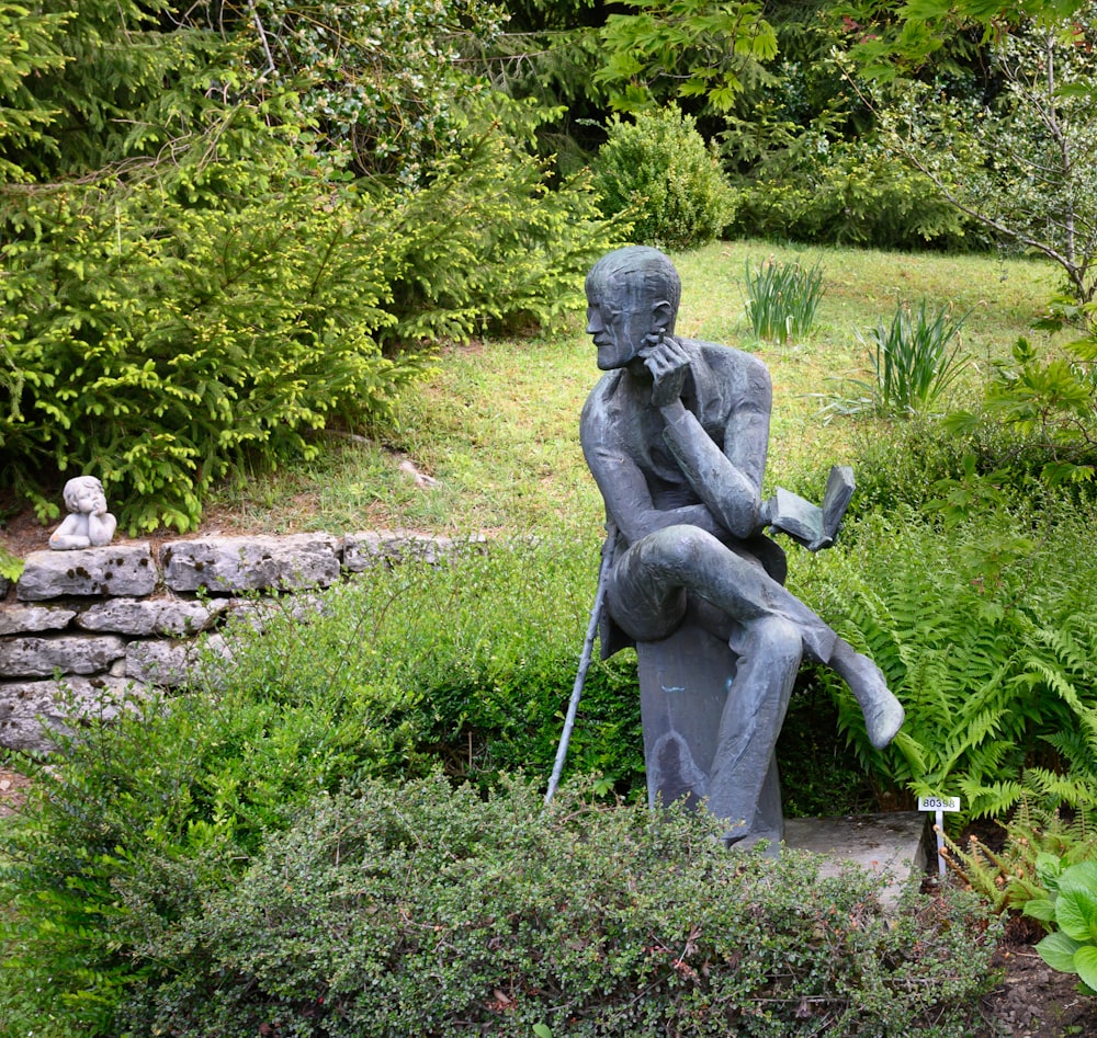 gray concrete statue of man holding stick