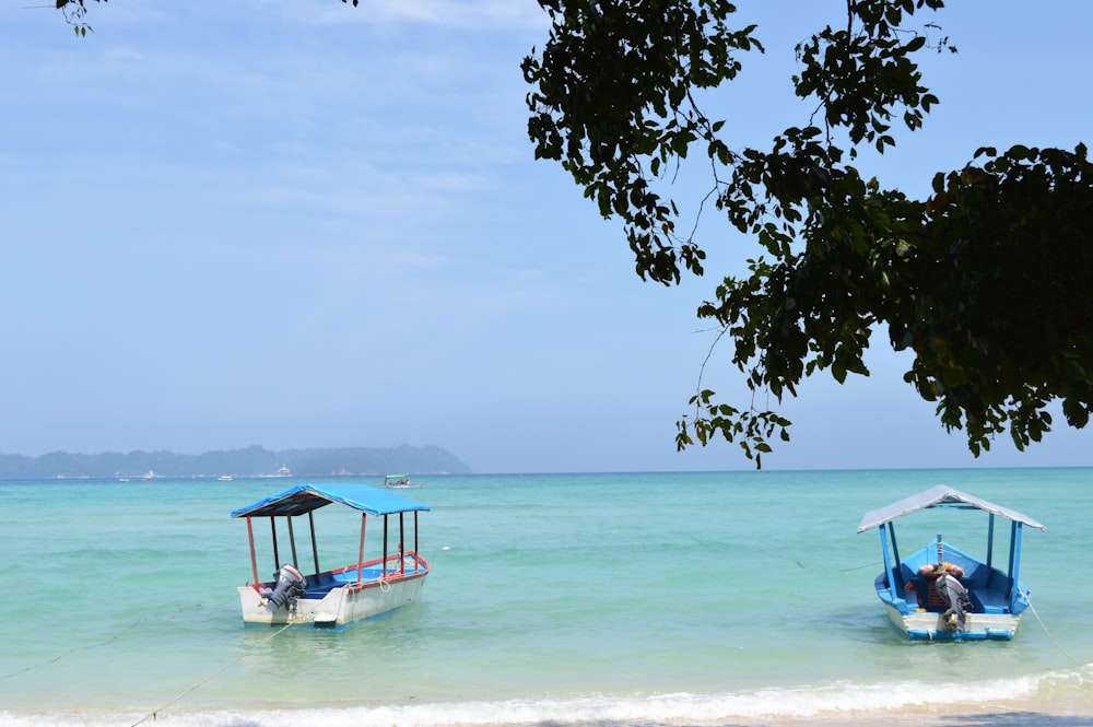 person sitting on blue and white boat on sea during daytime