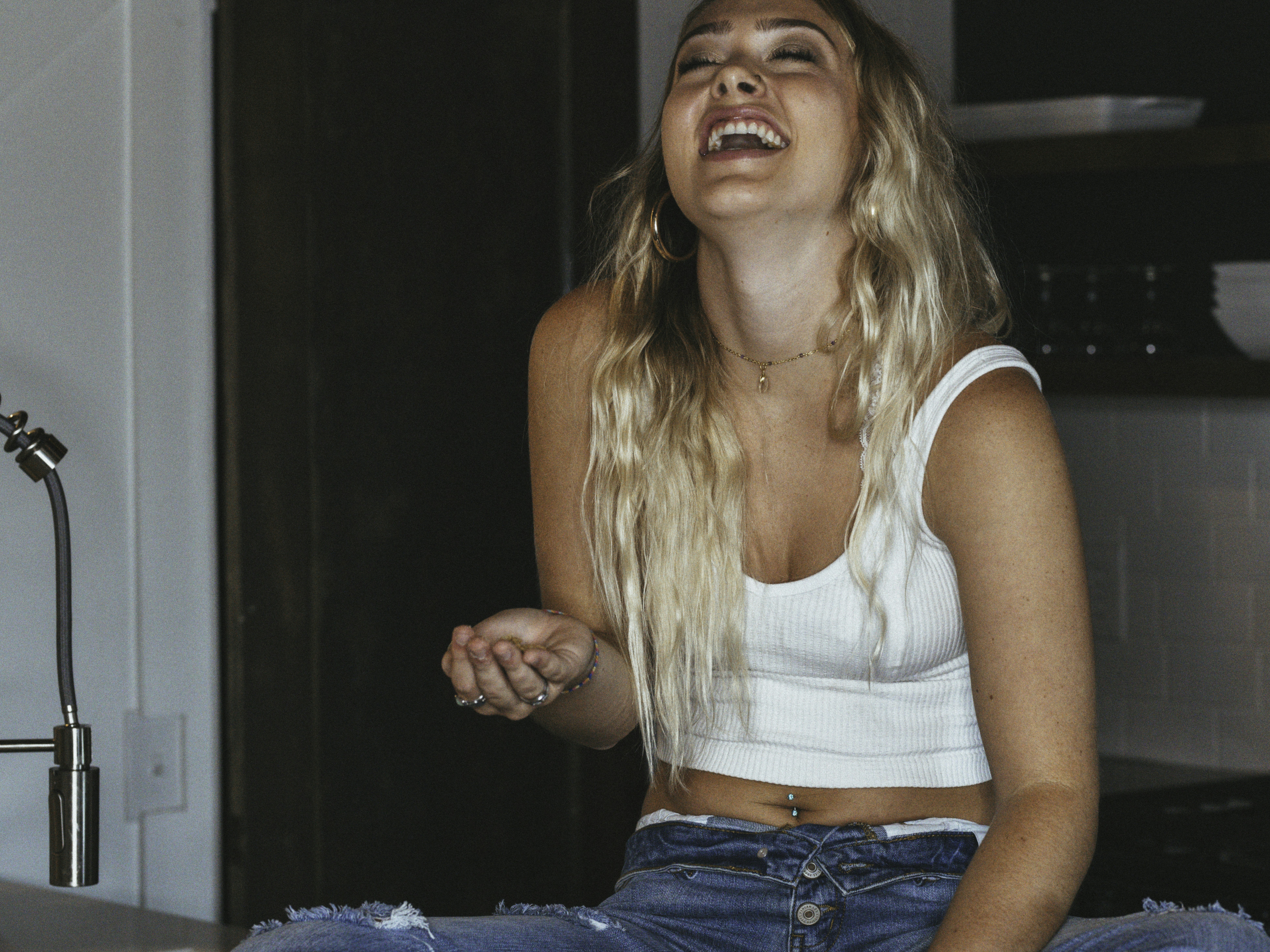 woman in white tank top and blue denim jeans