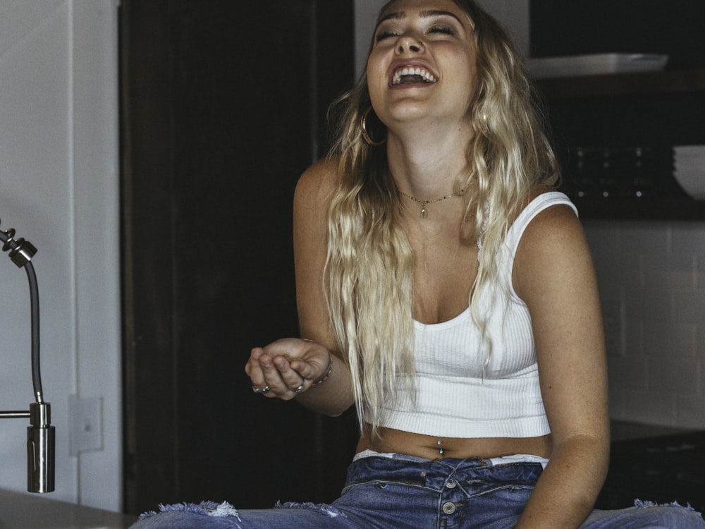 woman in white tank top and blue denim jeans