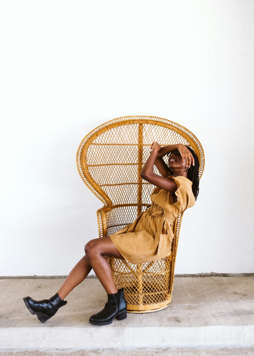 woman in yellow dress sitting on brown woven chair
