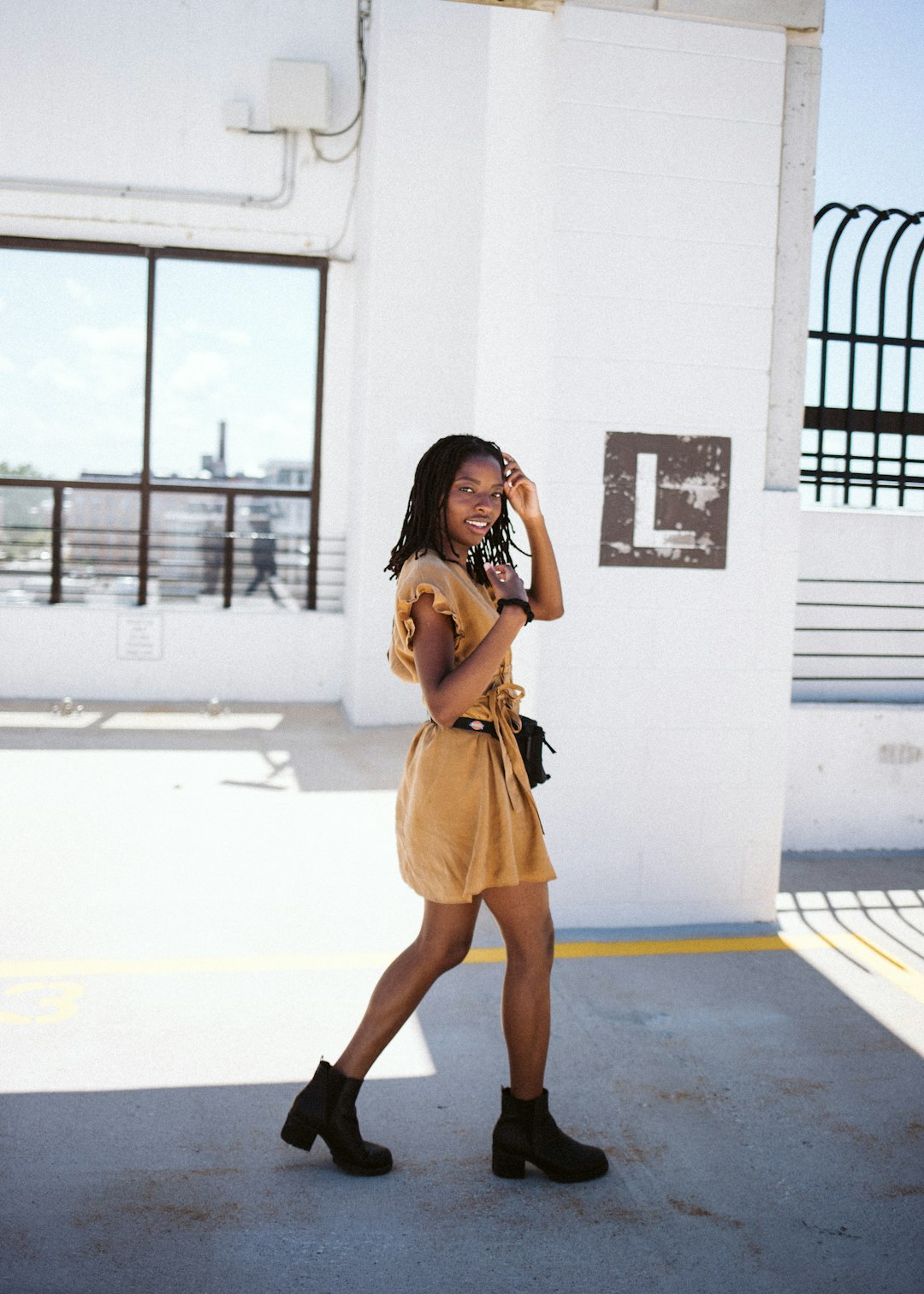 woman in yellow sleeveless dress standing on white floor