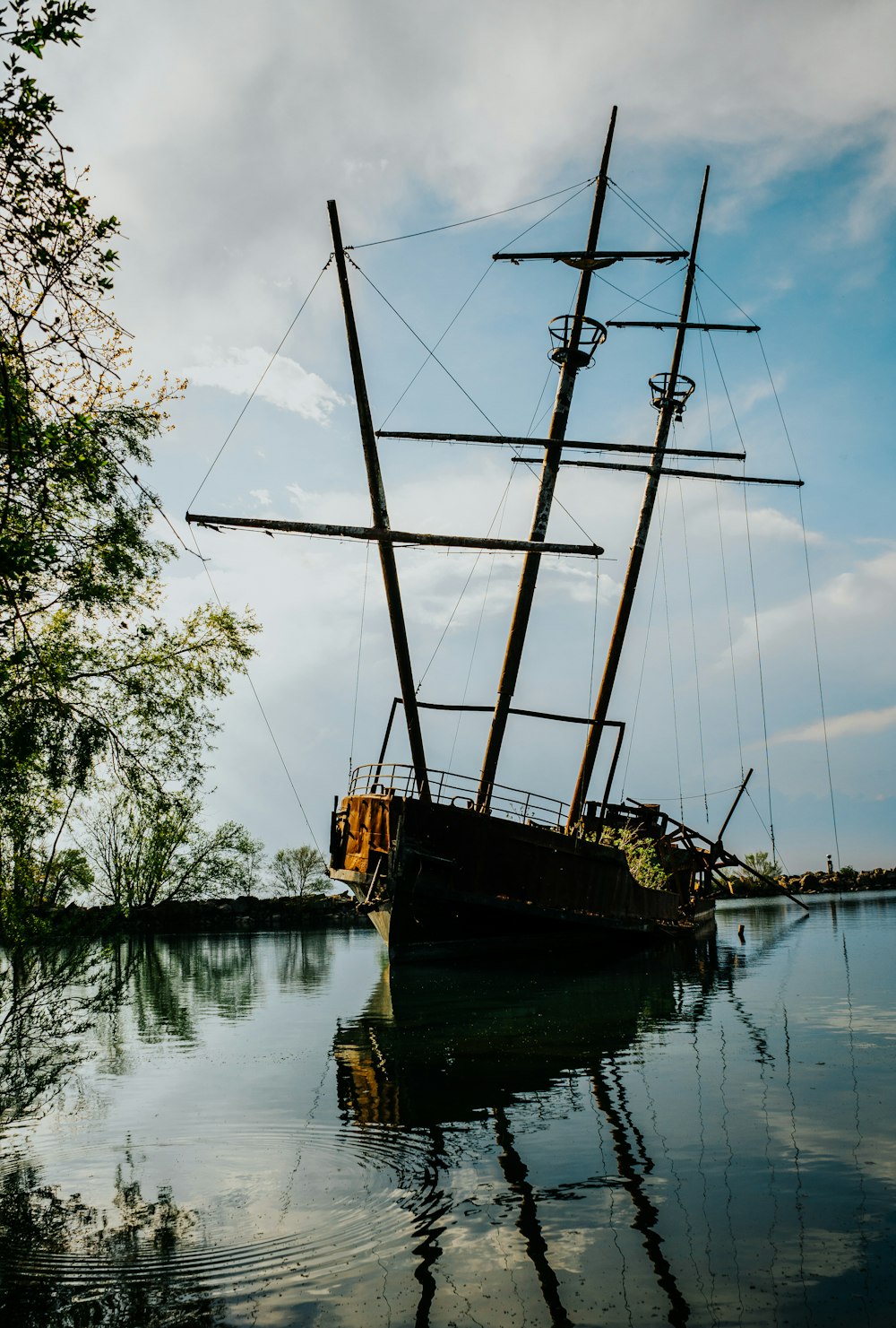 昼間の湖に浮かぶ茶色と黒の帆船