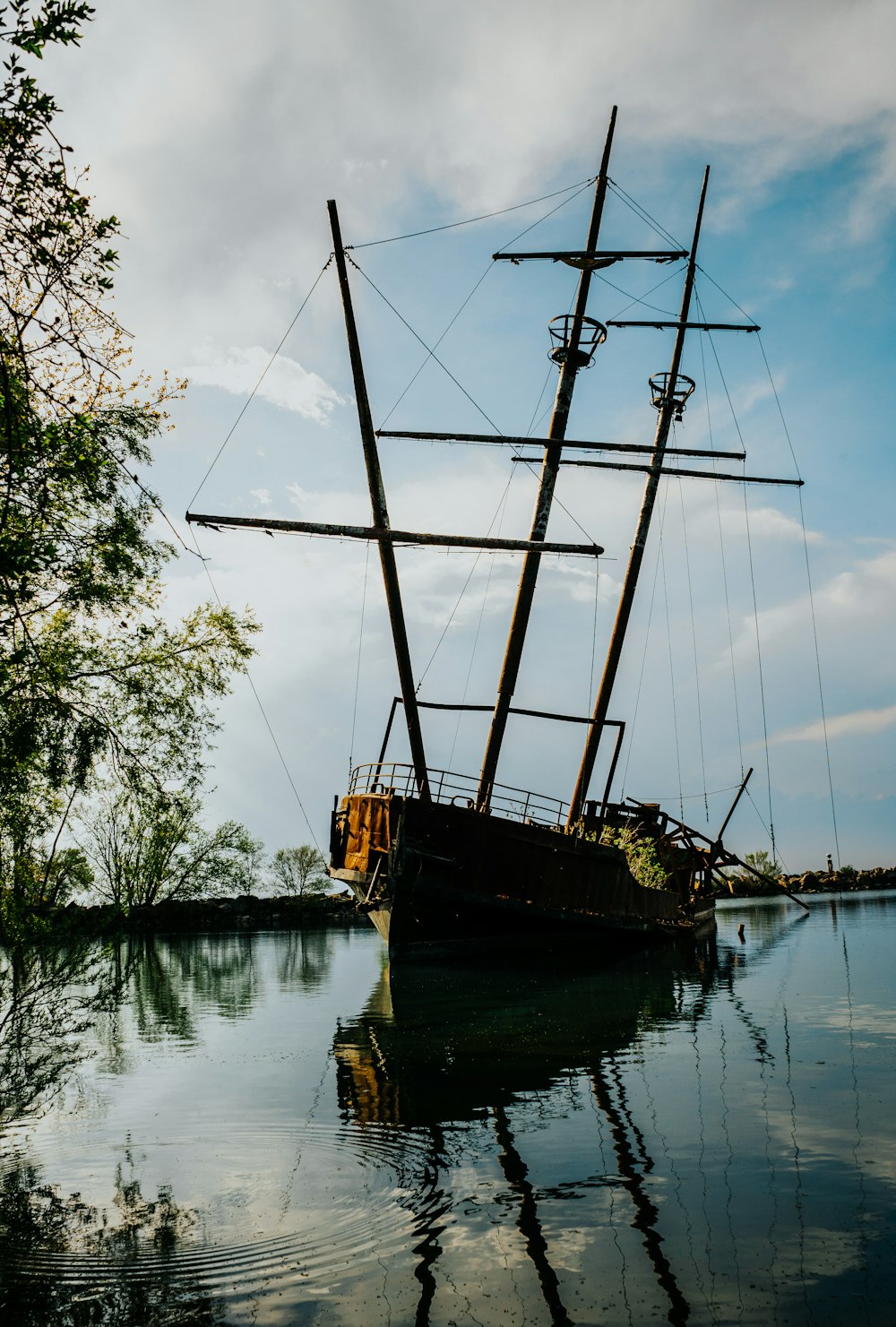 brown and black sail boat on lake during daytime