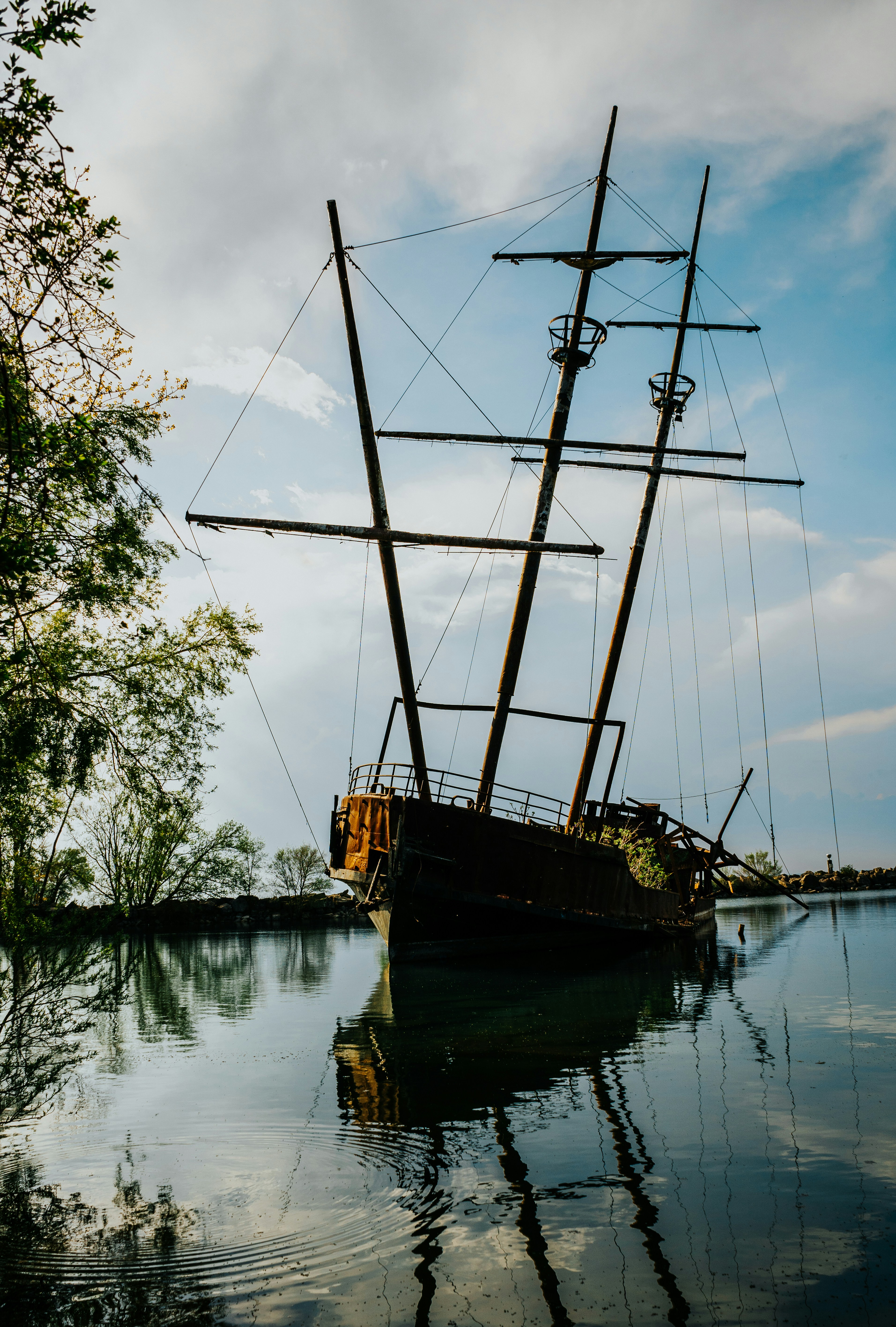 brown and black sail boat on lake during daytime
