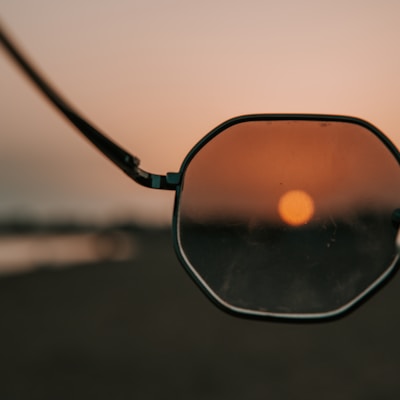 black framed sunglasses on beach during sunset