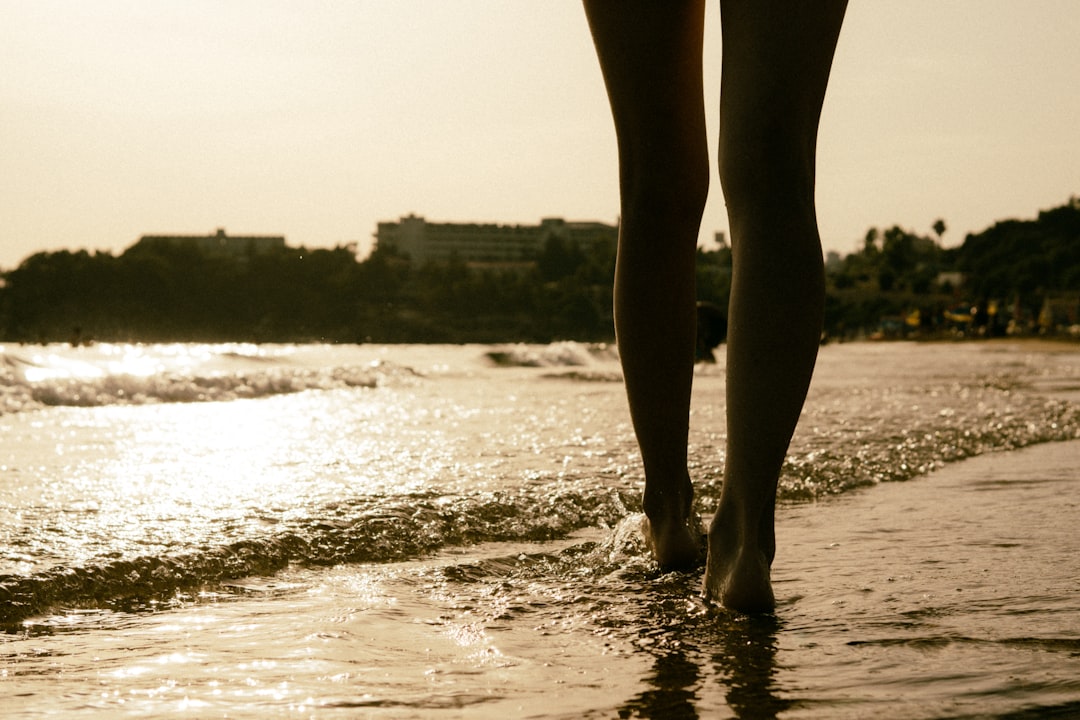 woman in black stockings standing on beach during daytime