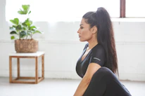 Close-up of a senior woman laughing while doing yoga in a bright, colorful room.